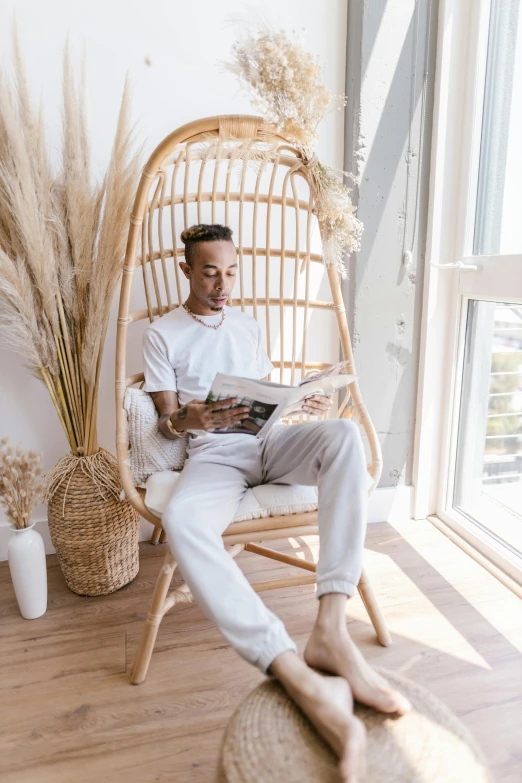 a man is reading a paper in a wicker chair