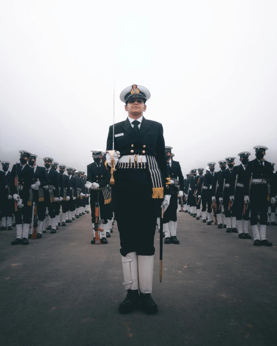 military men in uniform with a pipe marching in the background