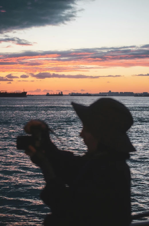 the woman is taking a picture of the sunset