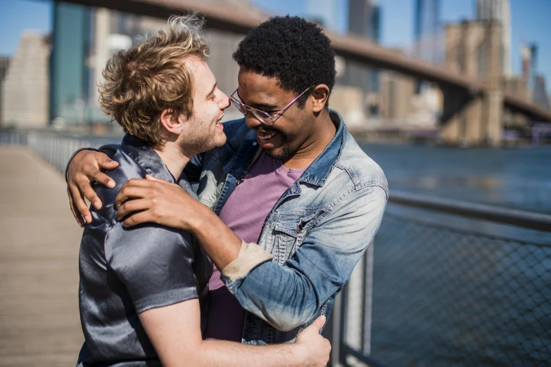 two men emcing in front of a city bridge