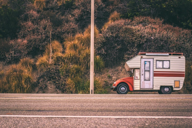 an old school bus parked at the side of a rural road