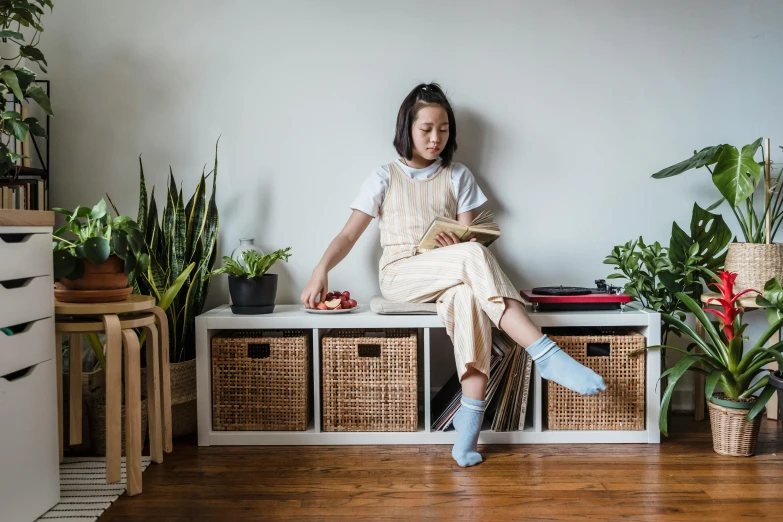 a woman sitting on top of a white cabinet