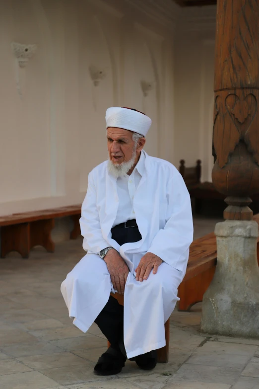 a man sitting on the ground next to wooden benches