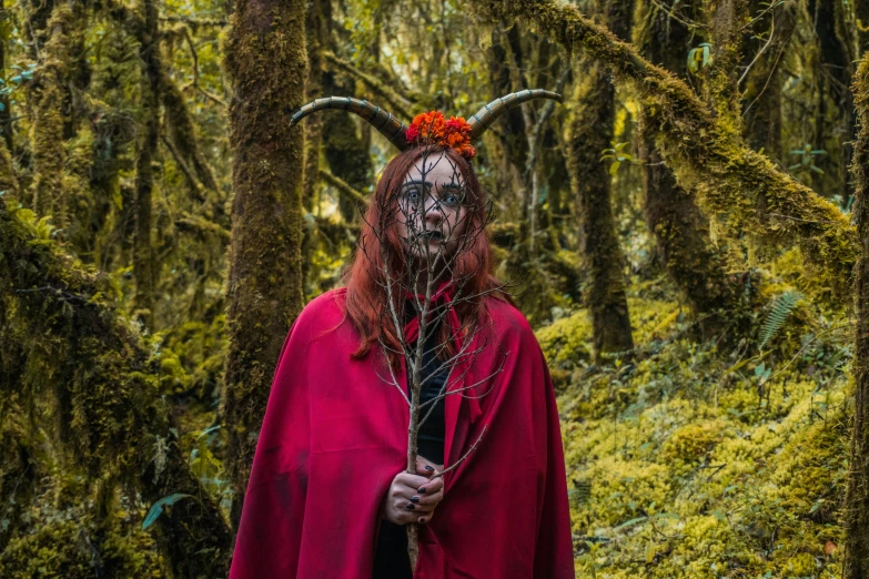 a man with horned horns standing in the woods