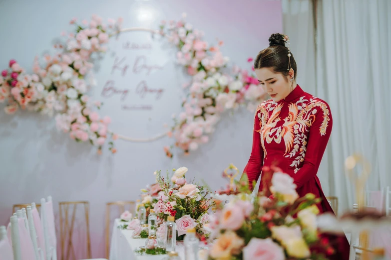 a woman that is standing near tables with flowers