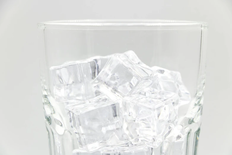 square glass filled with ice on top of a white table