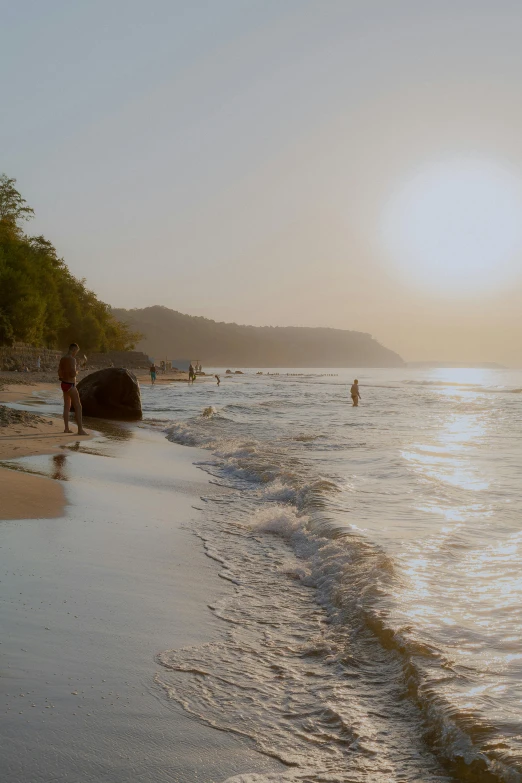 people at the water's edge on a beach