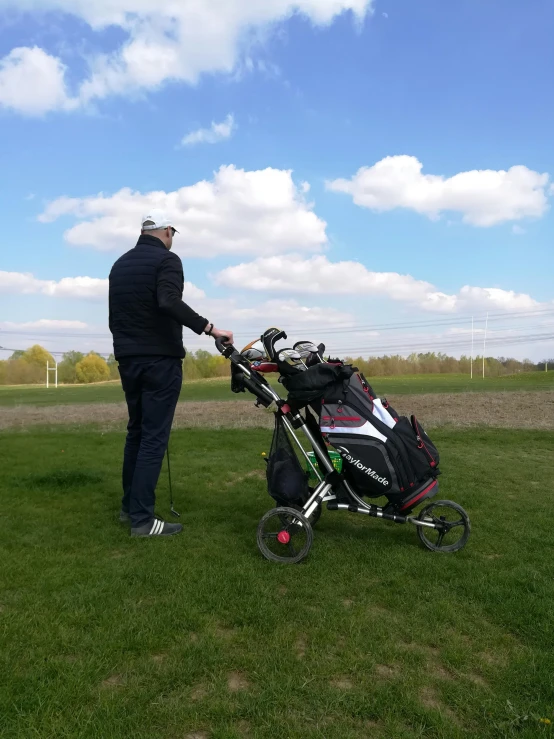 the man is pulling a cart with golf gear in it