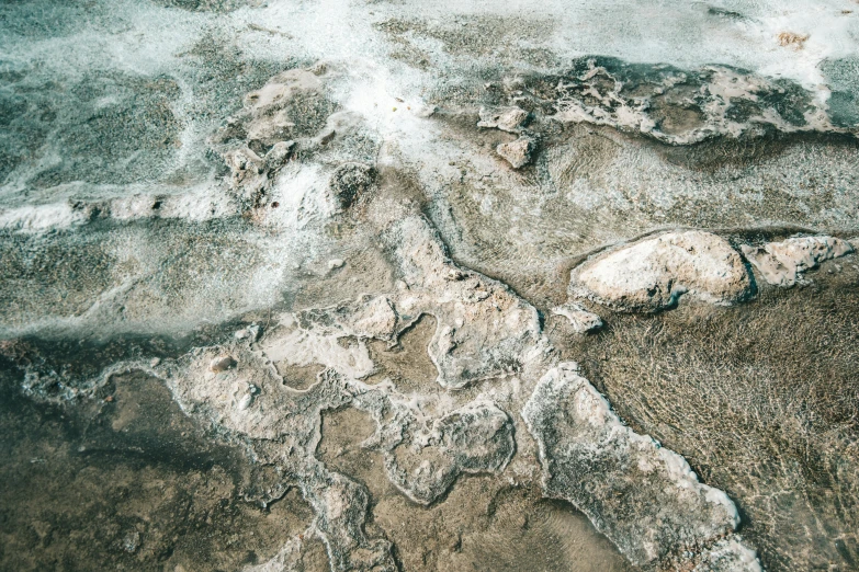 snow - covered rocks and water in front of an island