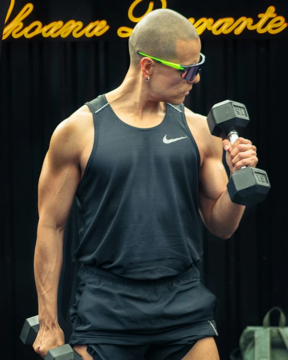 a young man wearing dark shorts is holding some dumbbells