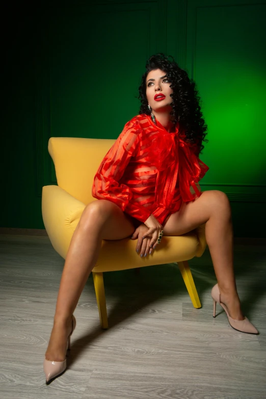 a woman wearing red poses for a po while sitting on a yellow chair