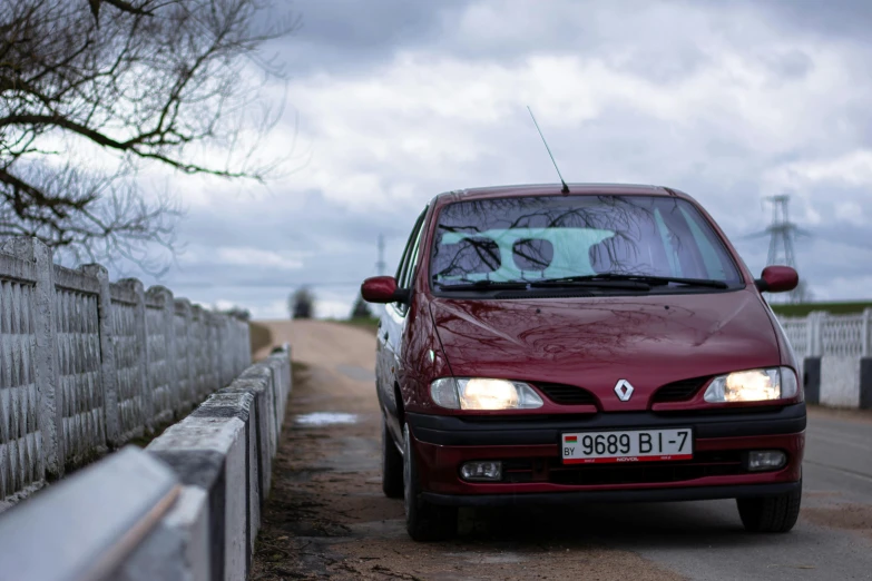 an automobile that is parked in front of a wooden fence