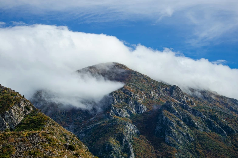 clouds cover the mountains with a blue sky