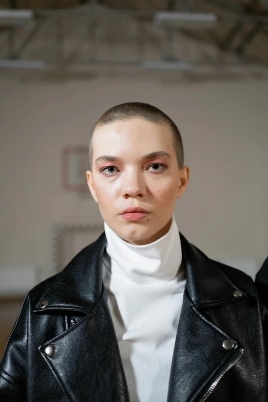 a model with short hair wearing a black leather jacket