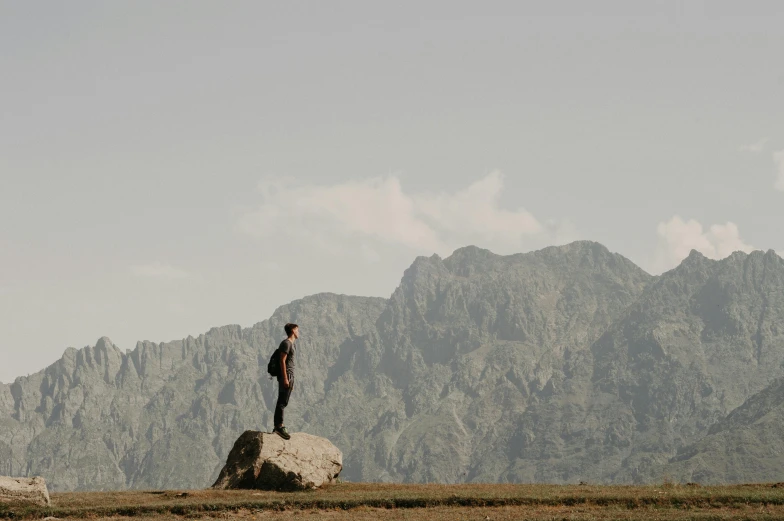 a man is standing on top of a large rock