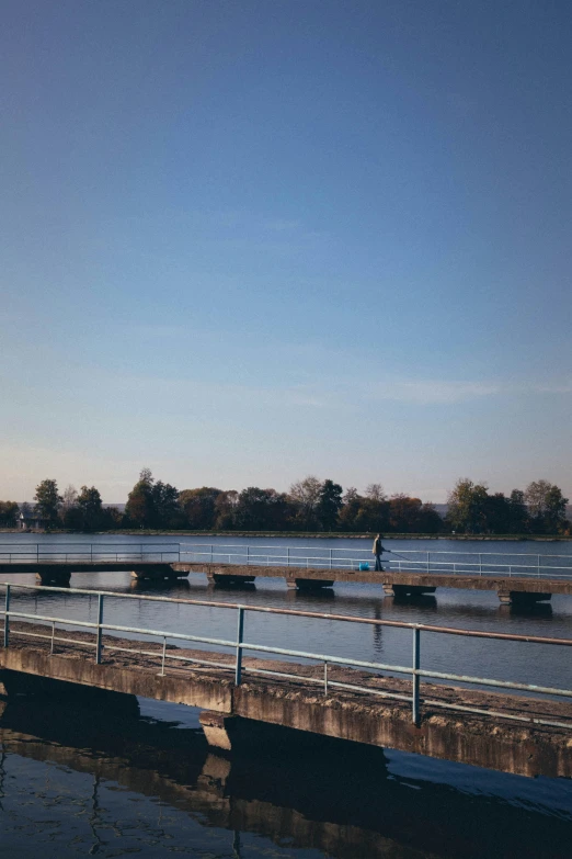 a person standing on the edge of a bridge overlooking the ocean