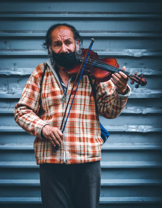 a man in orange shirt holding violin string and bow