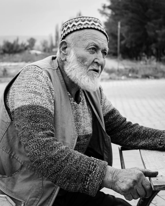 an older man in a knit hat sitting outside