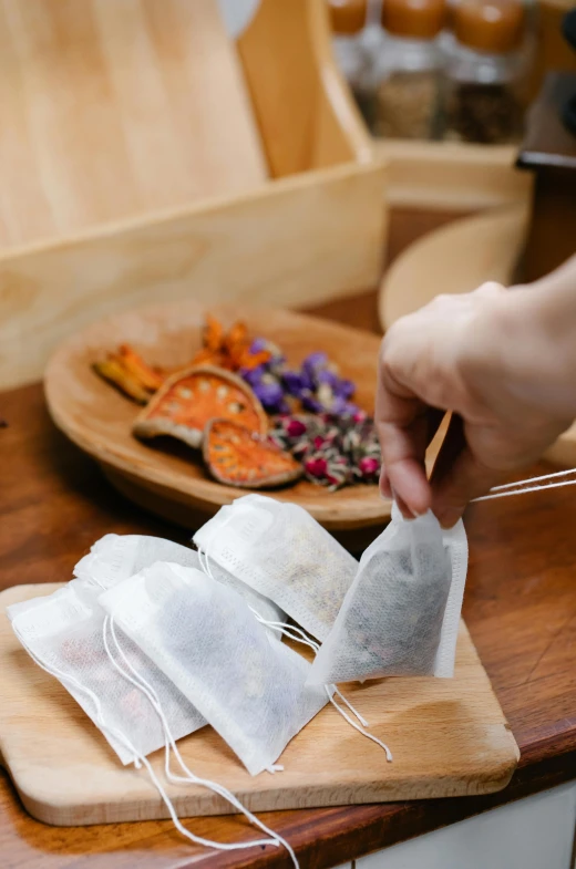 hands using chopsticks to string up some paper bags