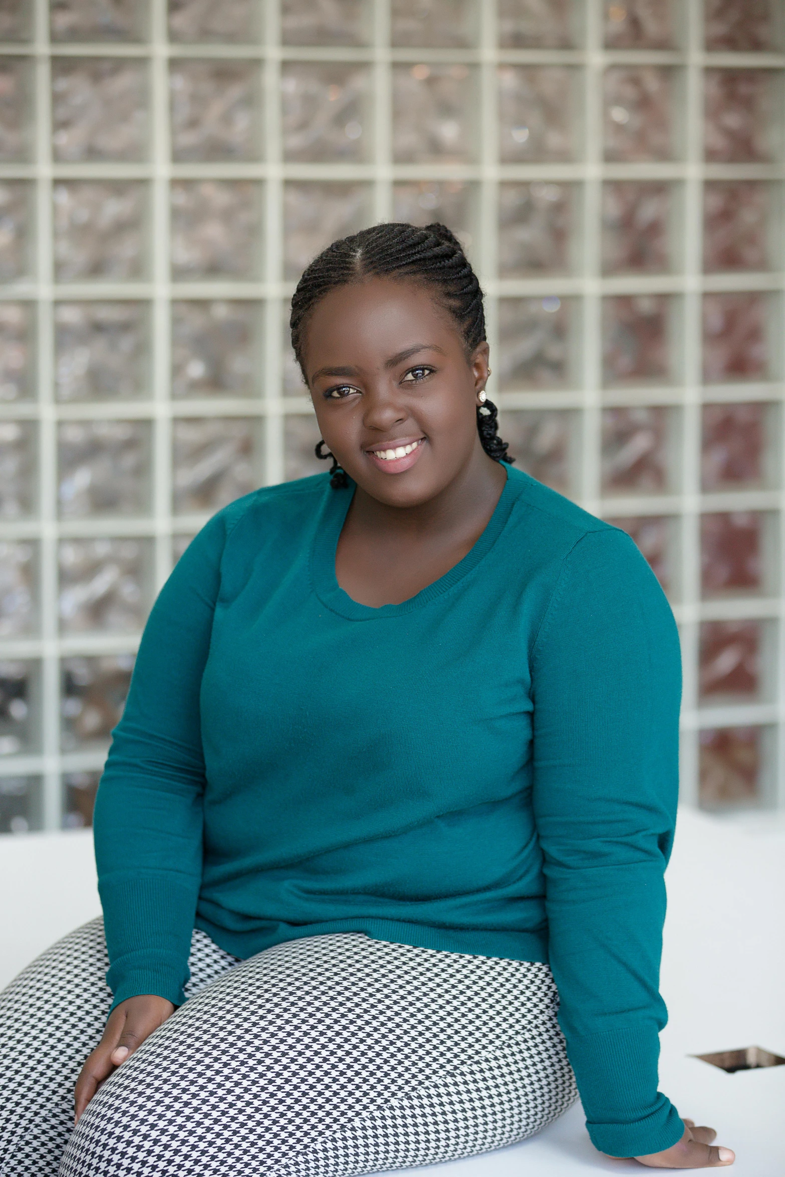 smiling woman in aqua sweater and black and white patterned pants