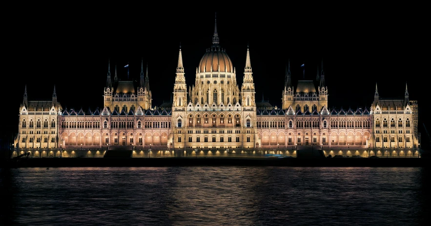 an illuminated castle and its reflection in water at night