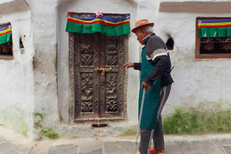 an old man walking past a door on a street