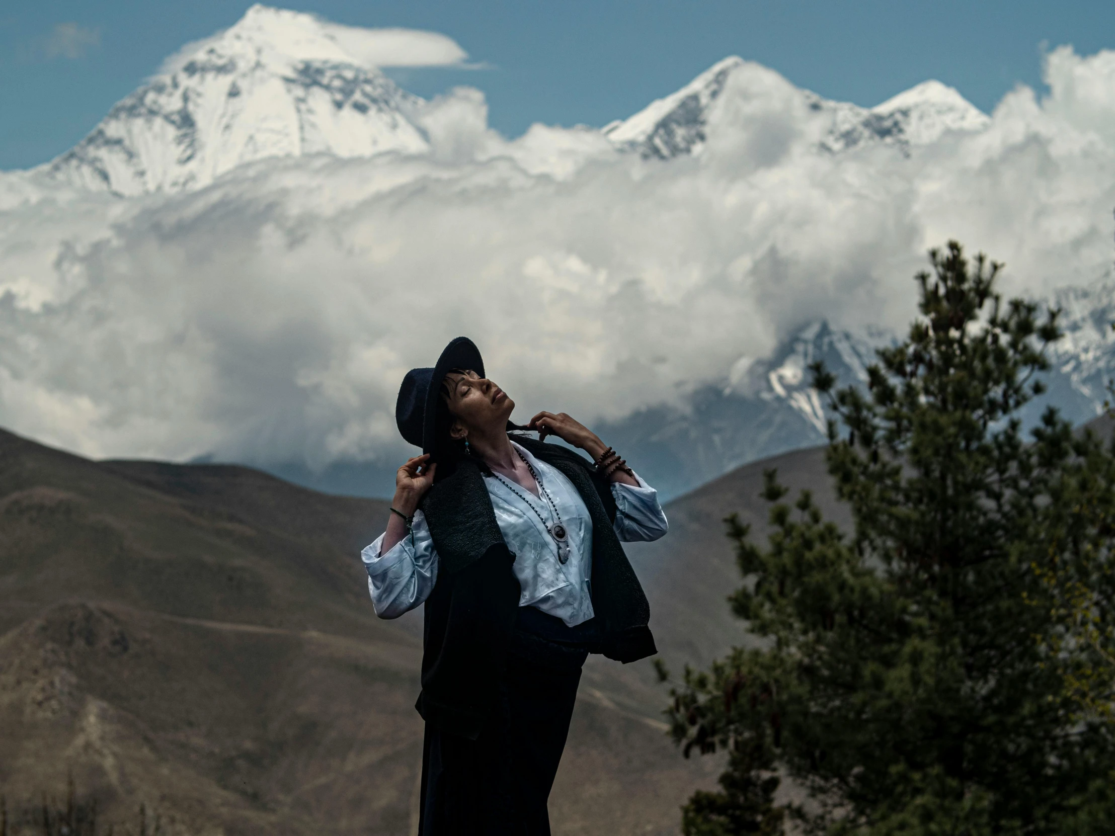 the woman is wearing a black hat and posing for the camera