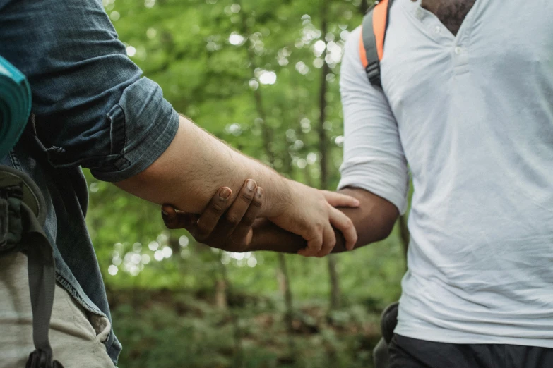 two men holding hands with the man in white