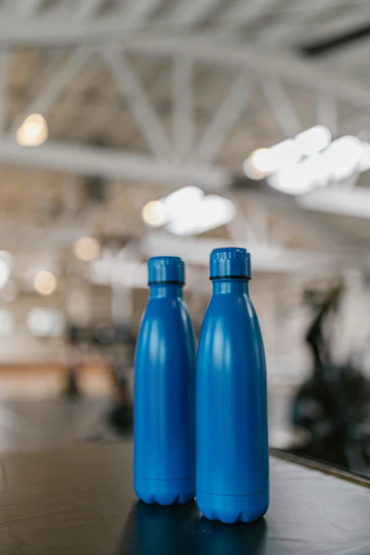 two blue plastic bottles sitting on a wooden table