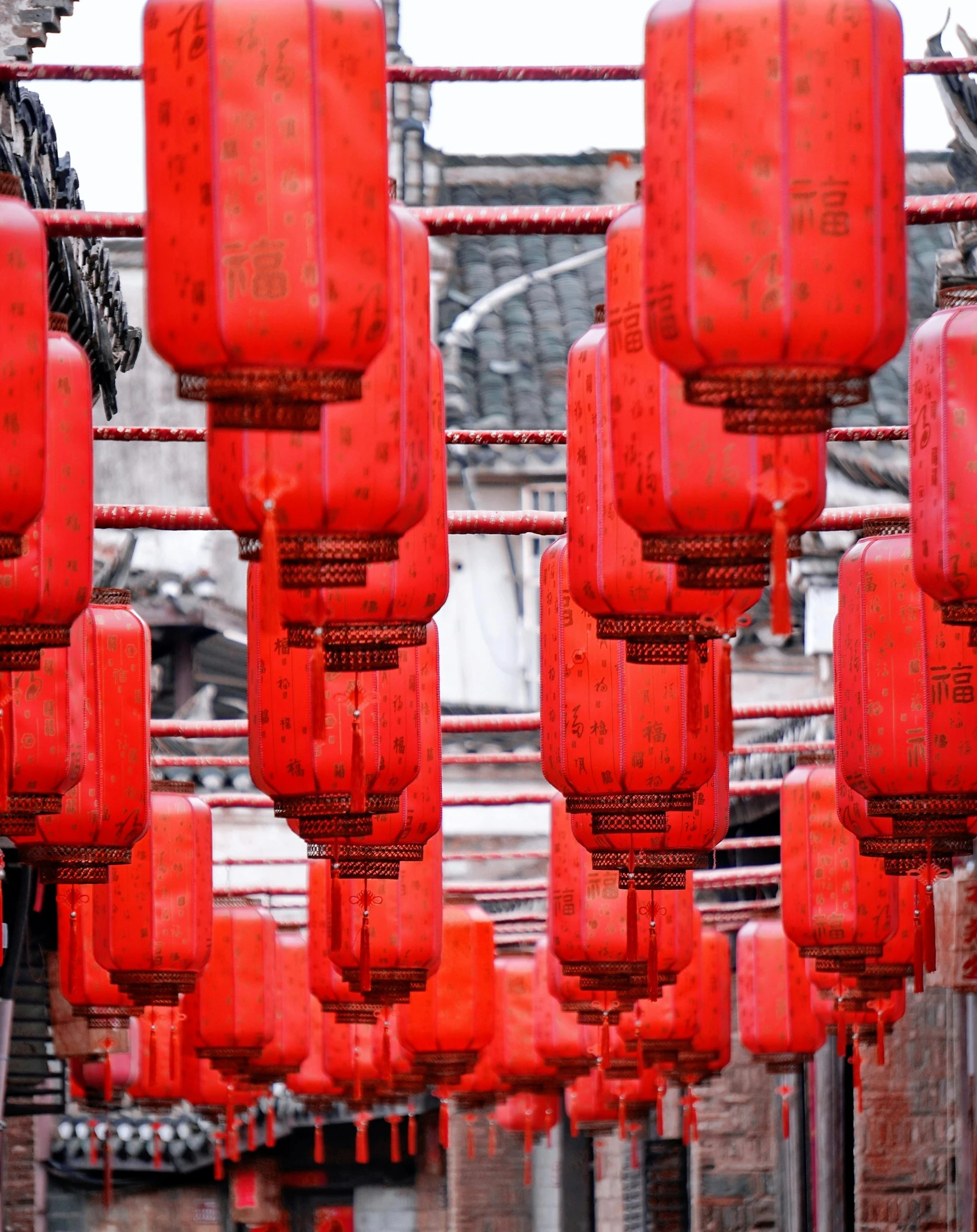 many red lanterns hanging from a metal pipe