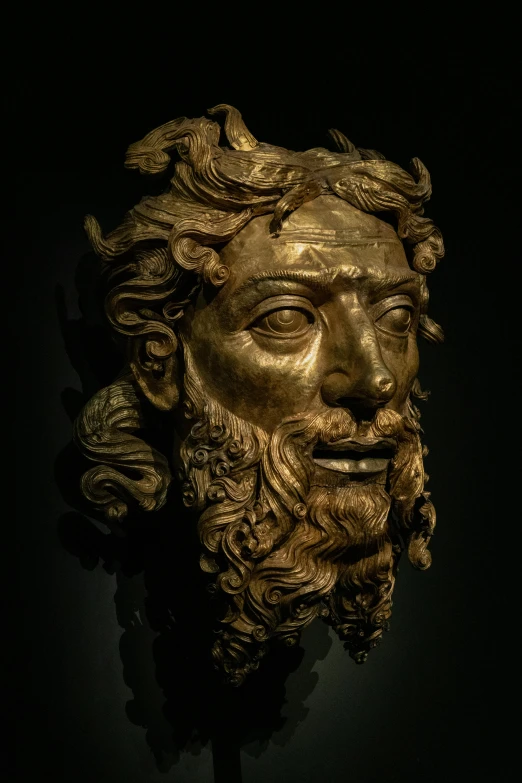 a gold mask with a beard and large eyes