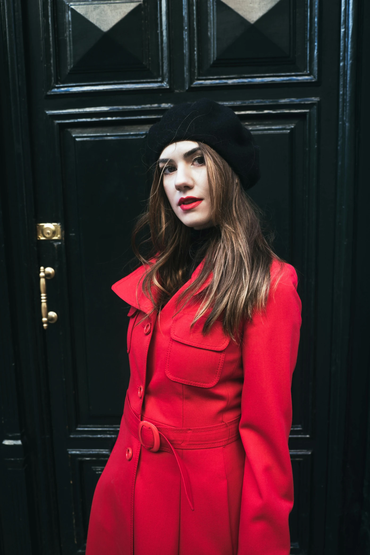 a woman wearing a red coat with black hat