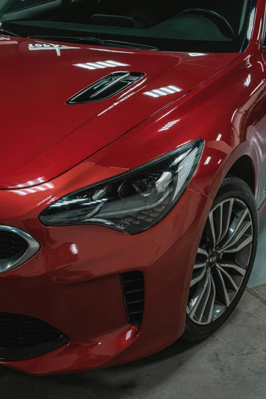 the front end of a red car in a parking garage