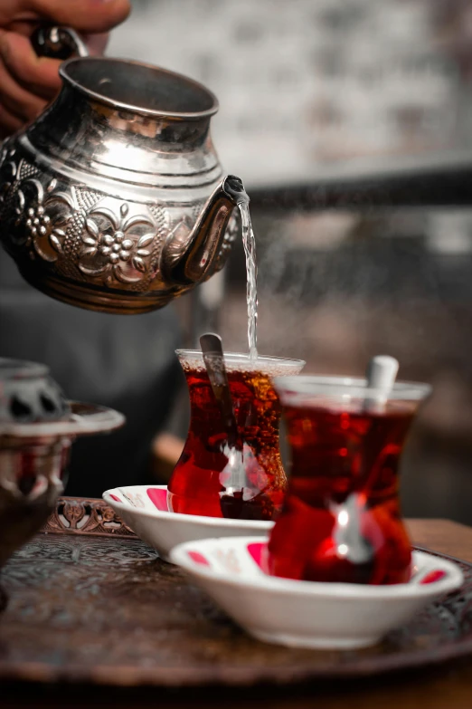 an image of beverage being poured in cups