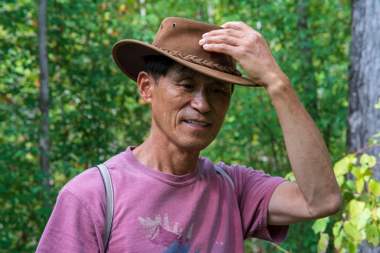 a man wearing a brown hat in the woods