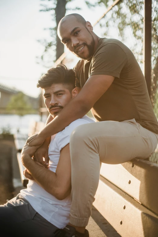 two men are sitting on a wooden bench