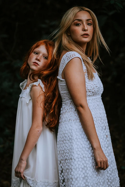 two red headed women in dresses standing side by side