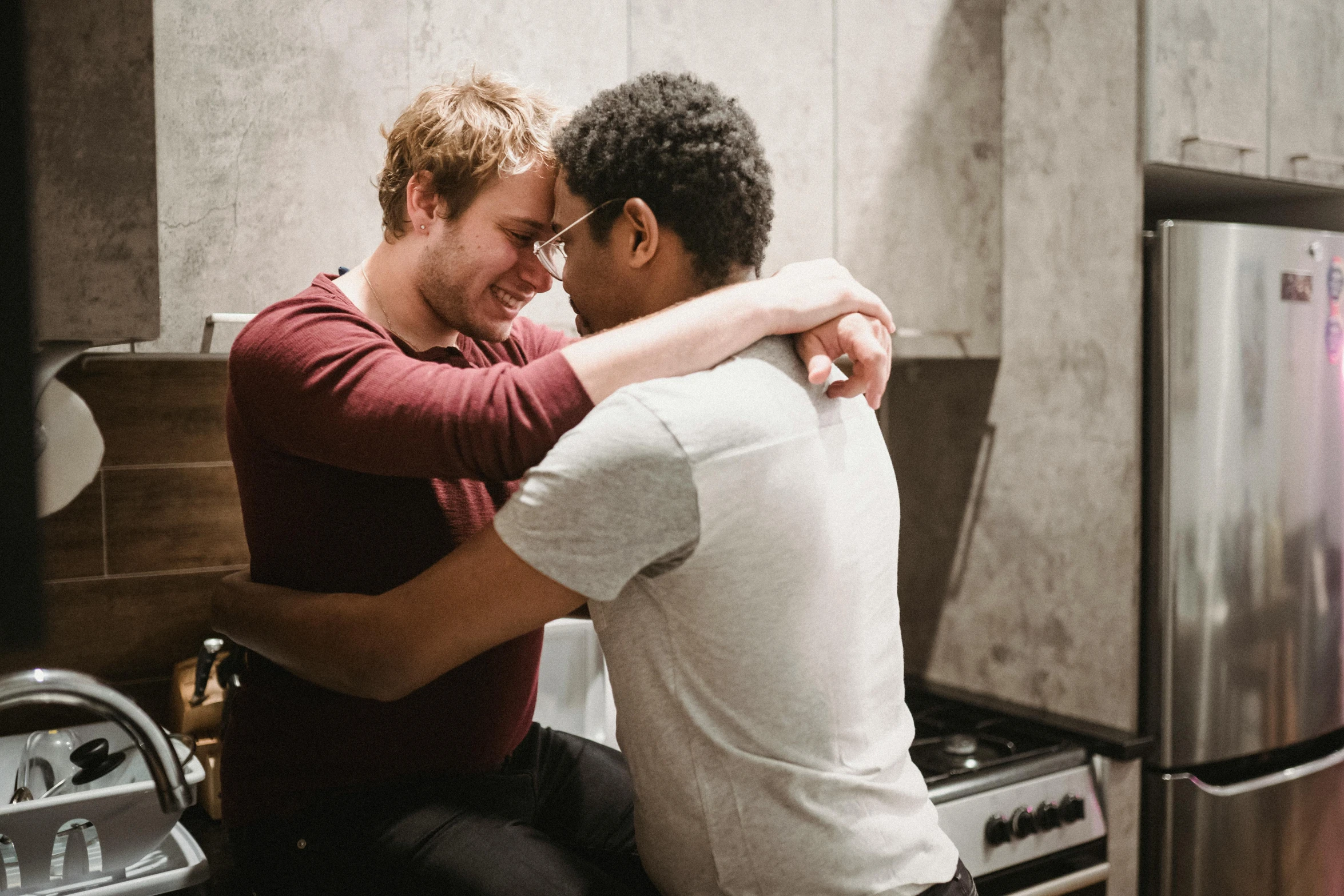 two men hugging and emcing in the kitchen