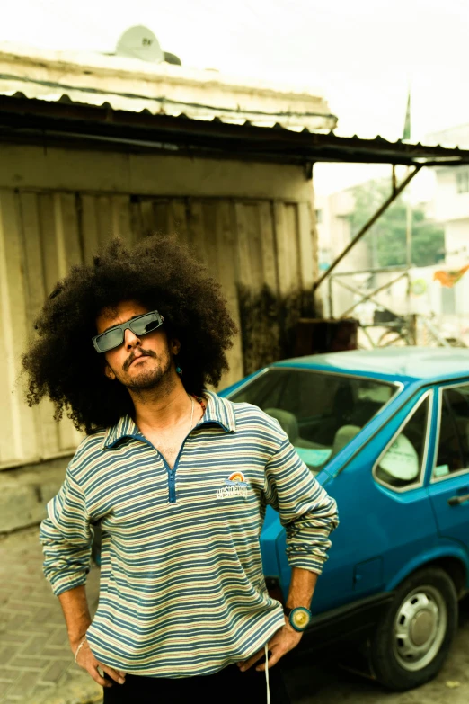 a man wearing sunglasses and standing next to his car