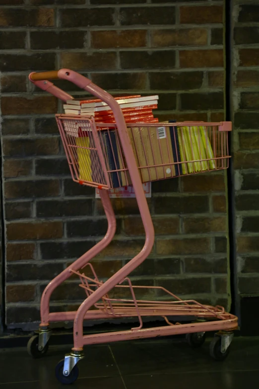 an orange shopping cart has many books in it