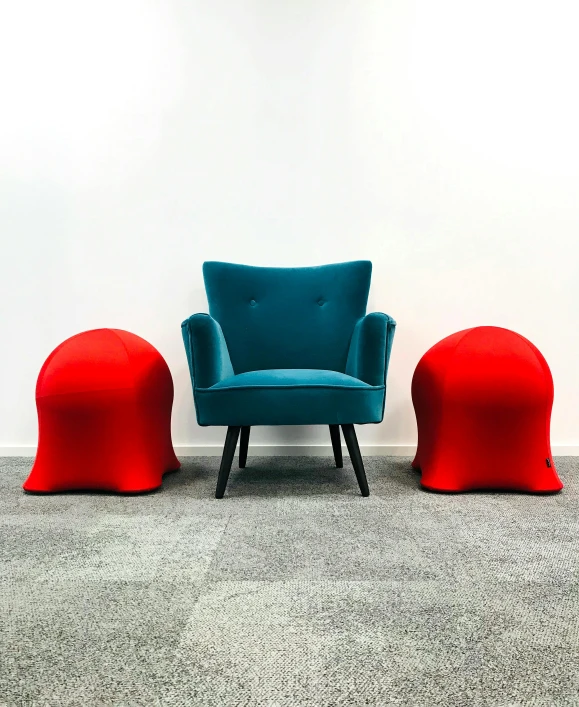 blue chairs and red ottomans against a white wall