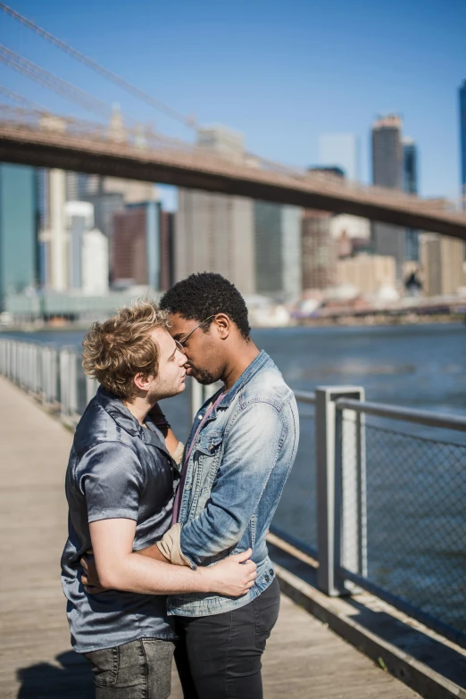 two people kissing each other on a bridge