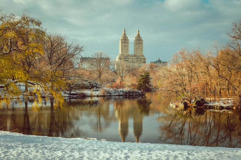 the view of a pond, church and some trees