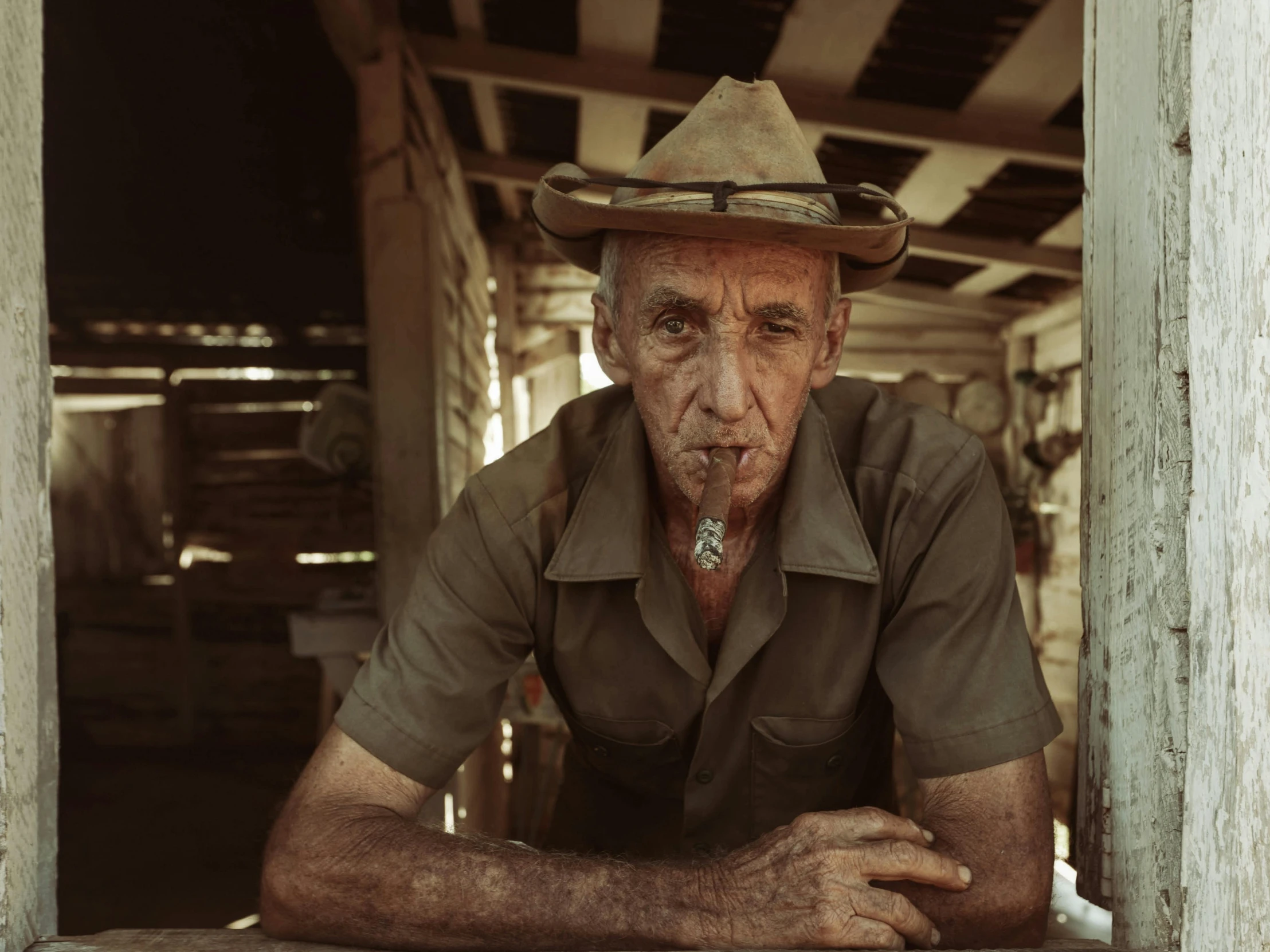 a man wearing a hat looking sad in the doorway