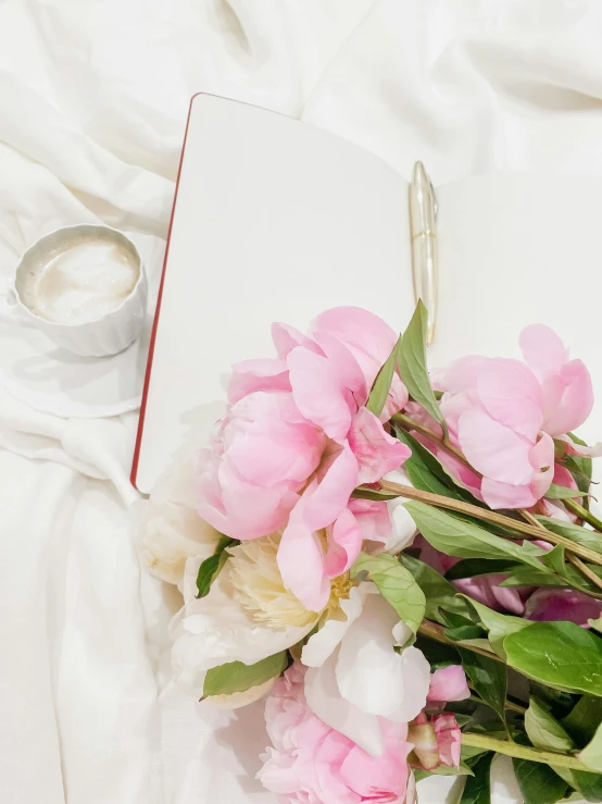 a close up of a book with flowers near by