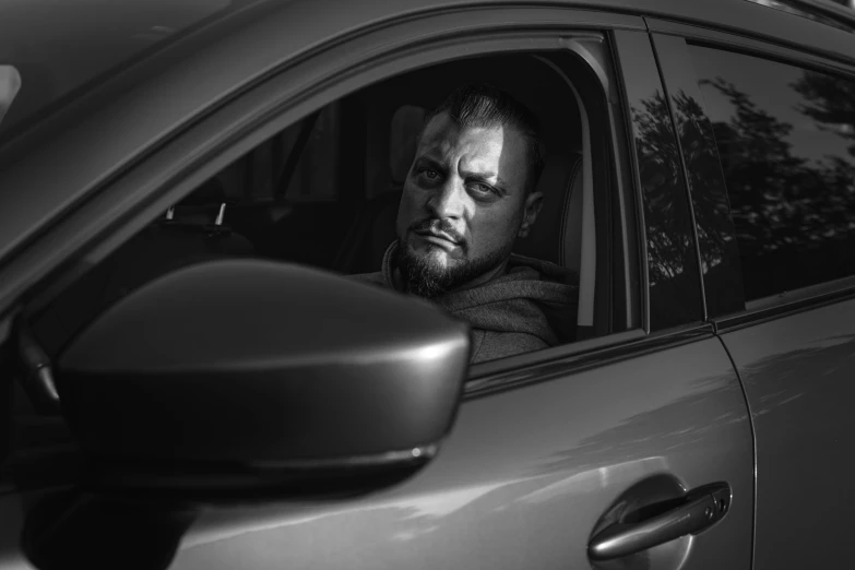 a man sitting in a car looking out the window