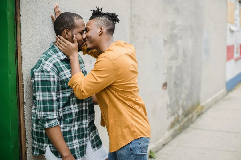 two young men talking to each other next to a building