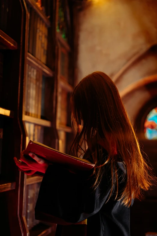 a person in a black coat leaning against a wall