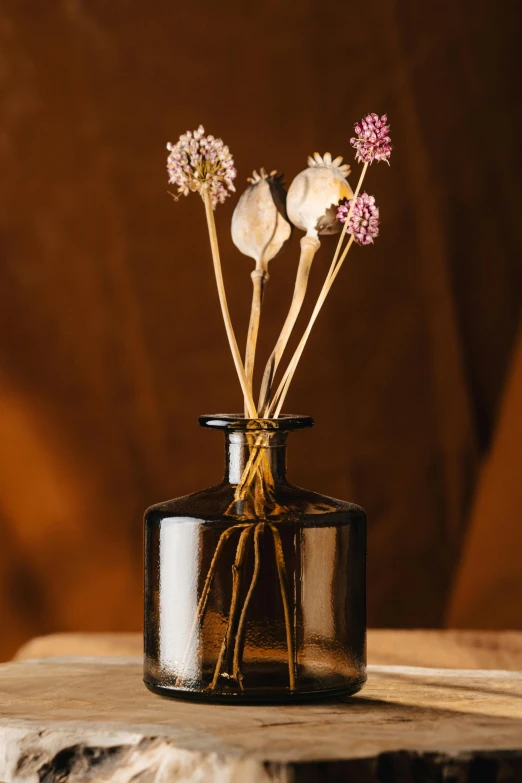 three small flowers are in a small glass vase