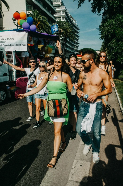 a woman in a green dress being greeted by people